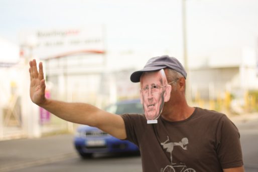 Un militant, masque de Gérard Mulliez sur le visage, remercie les clients de Décathlon de venir « remplir son porte monnaie ». (CP/Rue89 Bordeaux)