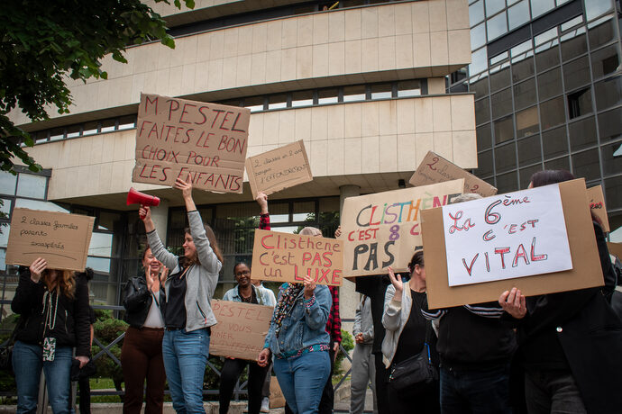 Photo montrant un rassemblement devant la Direction des Services Départementaux de l’Éducation Nationale de la Gironde (DSDEN 33) à Bordeaux. Une cinquantaine de parents, élèves et professeurs du collège Clisthène manifestent contre la fermeture d’une classe de sixième dans cet établissement scolaire expérimental. Pancartes, banderoles et expressions de mécontentement soulignent la mobilisation contre cette décision.
