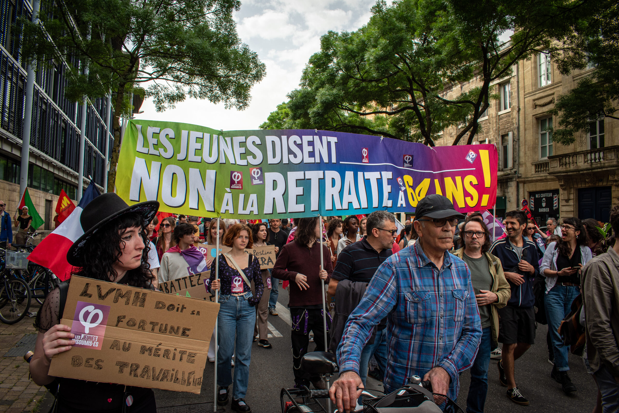 Manifestants à Bordeaux lors de la manifestation du 1er mai 2025, avec une banderole affichant "Non à l'âge de départ à 64 ans", symbole du rejet de la réforme des retraites de 2023.