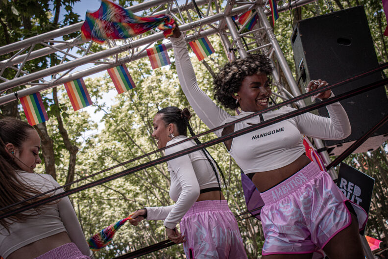 Participants et participantes de la Pride 2025 à Bordeaux défilent dans les rues, arborant drapeaux arc-en-ciel, pancartes militantes LGBTQIA+ et tenues colorées.