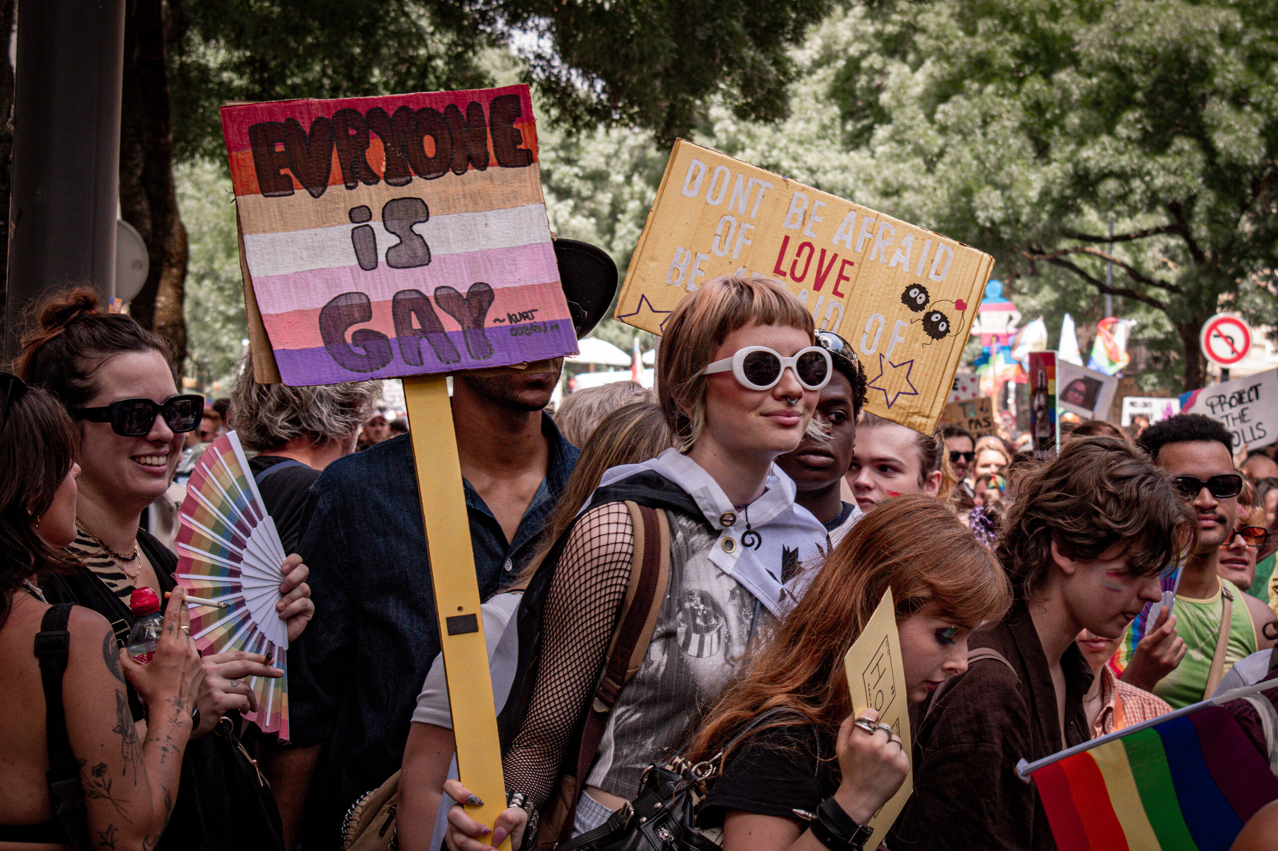 Participants et participantes de la Pride 2025 à Bordeaux défilent dans les rues, arborant drapeaux arc-en-ciel, pancartes militantes LGBTQIA+ et tenues colorées.