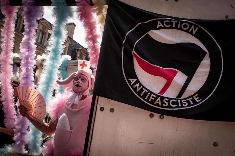 Participants et participantes de la Pride 2025 à Bordeaux défilent dans les rues, arborant drapeaux arc-en-ciel, pancartes militantes LGBTQIA+ et tenues colorées.
