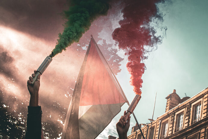 Deux manifestants brandissent des fumigènes aux couleurs de la Palestine à Bordeaux, lors d'une manifestation de soutien.
